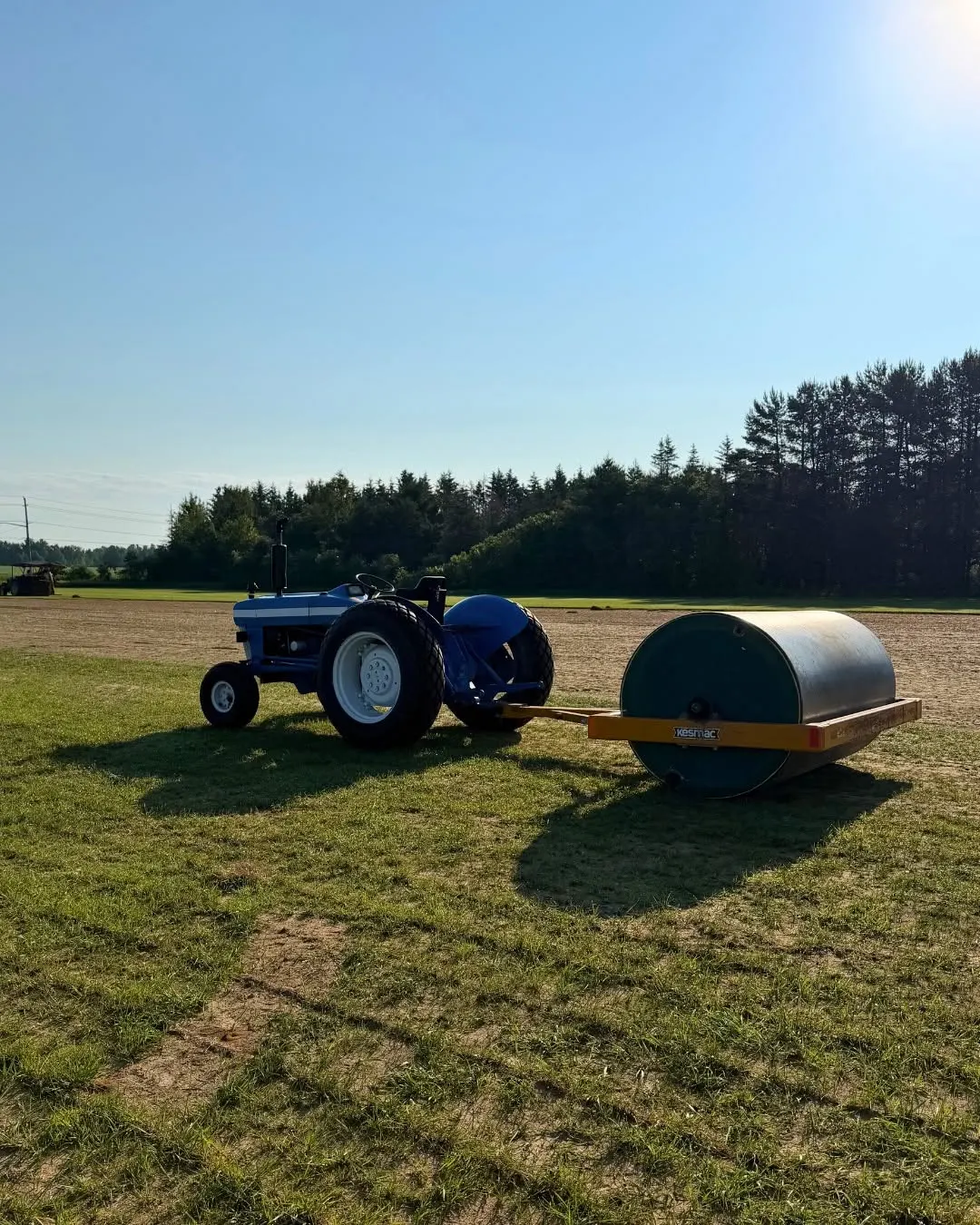 A tractor and turf roller beside the fields at North Range Sod.